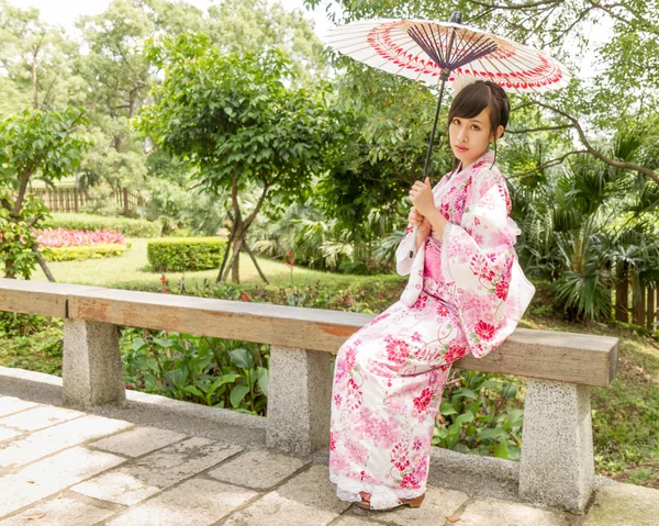 Asiatisk kvinna som bär en yukata i japansk stil trädgård — Stockfoto