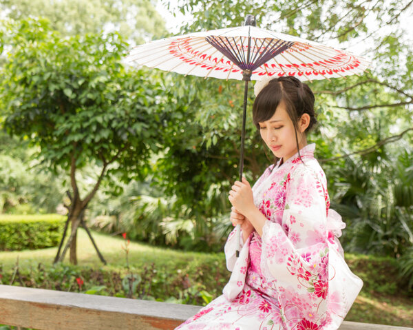 Asian woman wearing a yukata with an umbrella in Japanese style 