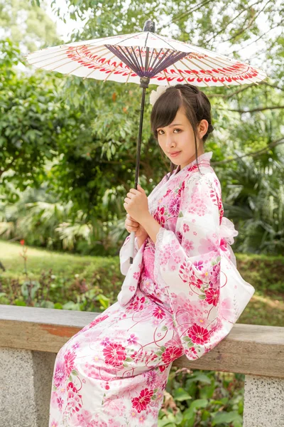 Asian woman wearing a yukata in Japanese style garden — Stock Photo, Image