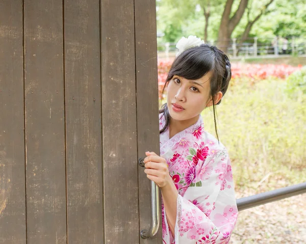 Aziatische vrouw die een kimono draagt in Japanse tuin — Stockfoto