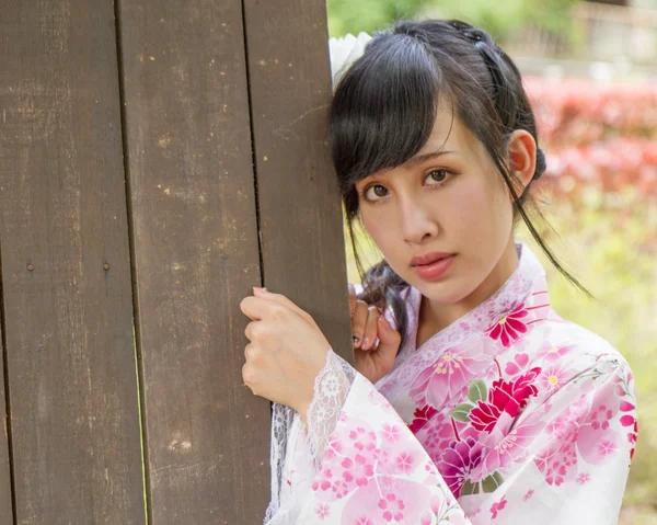 Asian woman next to door wearing a kimono — Stock Photo, Image