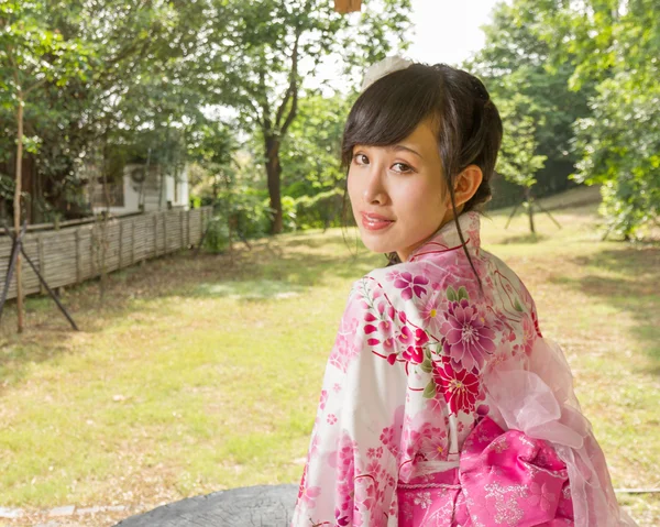 Mujer asiática usando un kimono en jardín japonés — Foto de Stock