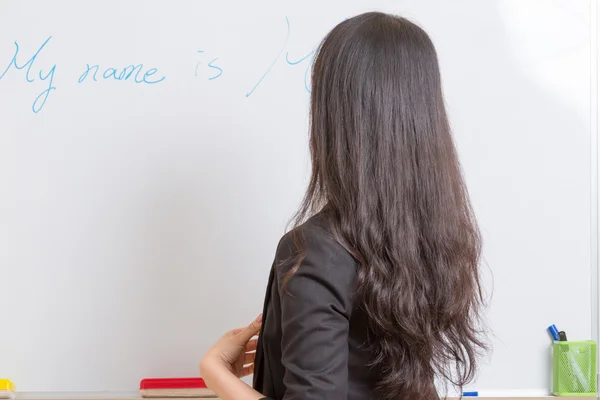 Teacher at whiteboard writing with blue marker — Stock Photo, Image