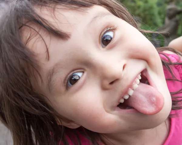 Jeune fille qui sort la langue tout en faisant un drôle de visage — Photo