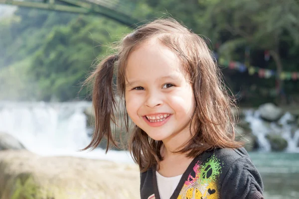 Young girl in front of waterfall — Stock Photo, Image