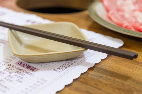 Yemek çubukları ile Çince menü altında baharat çanak üzerinde — Stok fotoğraf