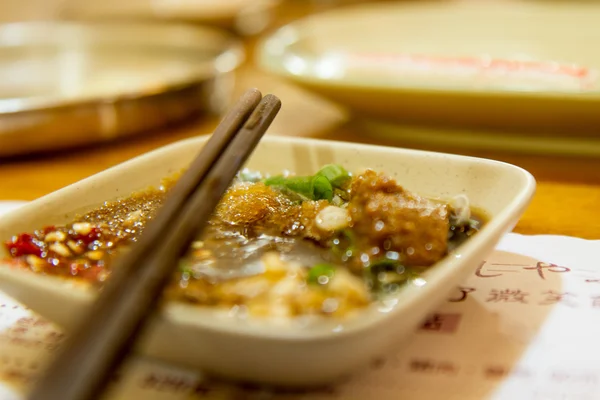 Chopsticks on spice dish with Chinese menu underneath — Stock Photo, Image