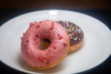 Beyaz tabakta çilekli ve çikolatalı çörekler.