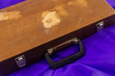 Mor kumaş arka planı olan eski ahşap kutu.