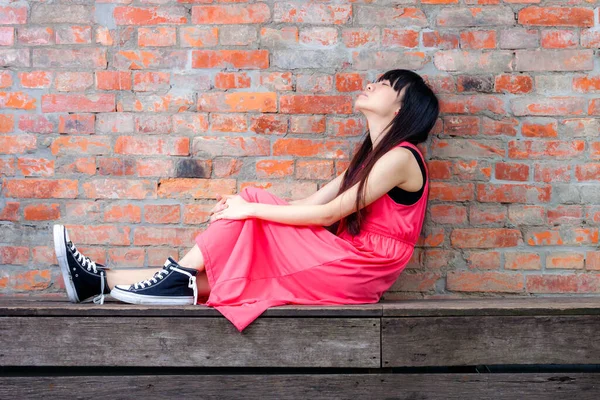 Young Asian Woman Sitting Red Brick Wall Feeling Pensive — Stock Photo, Image