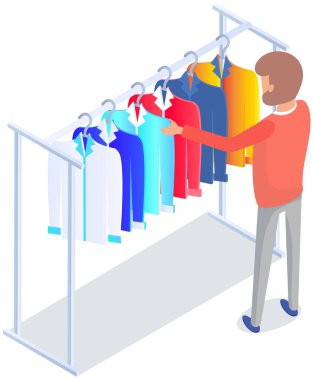 Mağazada kıyafet seçmek, alışveriş konsepti. Erkek alıcı soyunma odasında kıyafet seçer. Alışveriş merkezinde askıda asılı elbisesi olan bir müşteri. Alışverişçi mağazanın ya da butiğin soyunma odasında duruyor.