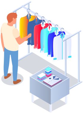Mağazada kıyafet seçmek, alışveriş konsepti. Erkek alıcı soyunma odasında kıyafet seçer. Alışveriş merkezinde askıda asılı elbisesi olan bir müşteri. Alışverişçi mağazanın ya da butiğin soyunma odasında duruyor.
