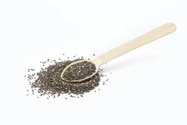 Chia tohumları beyaz arka planda tahta kaşıkla yayılmış.