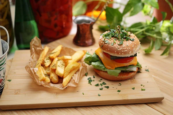 Vege cheeseburger and potato fries on a wooden cutting board. Vegan food set, lunch. Plant-based meal, horizontal view. — Stock Photo, Image