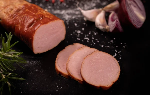 Smoked pork loin, tenderloin, on black background, blackboard. Polish cold cuts, meat products. — Stock Fotó