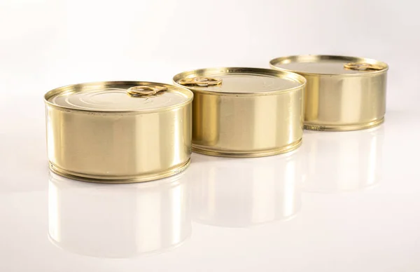 Drie metalen ronde blikken met trekkers, geïsoleerd. Ingeblikt voedsel, blanco. Packshot foto voor pakketontwerp, sjabloon. — Stockfoto