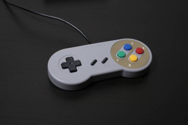 Siyah arka planda retro oyun sahası. Eski usul konsol kontrolörü, video oyunları bloknotu, yatay görüş. Klasik oyun aksesuarları. 