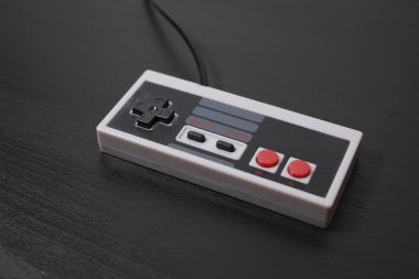 Siyah arka planda retro oyun sahası. Eski usul konsol kontrolörü, video oyunları bloknotu, yatay görüş. Klasik oyun aksesuarları. 