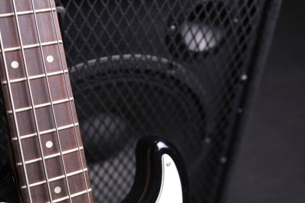 Electric guitar fretboard, neck, close up. Music instrument and loudspeaker in a rehearsal room.