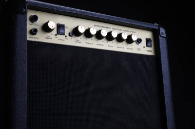 Siyah gitar amplifikatörü, siyah arka planda amplifikatör, yakın plan. Prova odasındaki aletler..