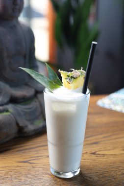 Pina colada içeceği. Kokteyl, rom, hindistan cevizi sütü ve ananaslı, tahta bir arka planda, uzun bir bardakta. Alkolik içki..