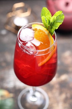 Kırmızı kokteyl, spritz, uzun bardakta bir içki, buz küpleri, portakal dilimleri ve nane yaprakları, seçici odaklanma, yakın çekim..