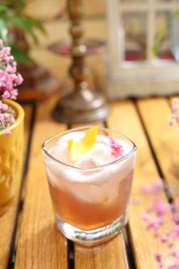 Köpüklü viski kokteyli, portakal suyuyla süslenmiş, seçici odaklanma. Klasik içki, viski, burbon, limon suyu, şeker ve yumurta beyazı, eski moda bir bardakta, ahşap bir masada..