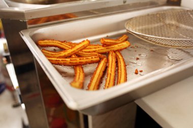 Churros üretimi. Geleneksel kızarmış hamur servisi yapan yemek kamyonu, İspanya, Portekiz 'den tatlı. İnce ve uzun tatlı tatlı üzerine tarçın şekeri serpiştirilmiş, sıcak çikolata ile servis edilir..