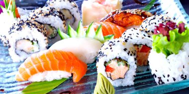 Suşi, maki ve nigiri ile hazır. Somonlu suşi, ton balığı, çiğ balık, mavi cam tabakta. Japon lezzeti..