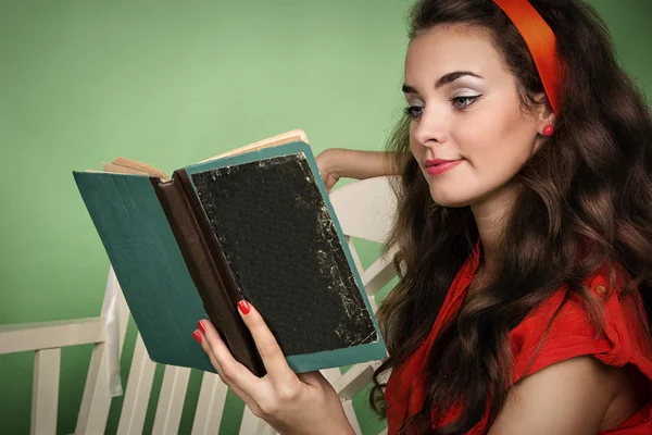 Menina em estilo retro com emoções lendo um livro Fotografias De Stock Royalty-Free