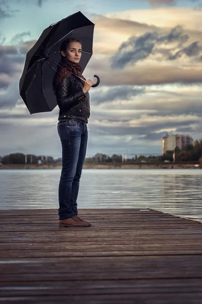 Girl with umbrella at a reservoir — Stock Photo, Image