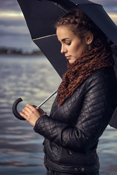 Girl with umbrella at a reservoir — Stock Photo, Image