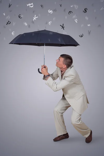 Homem com guarda-chuva em moeda chuva Imagens Royalty-Free