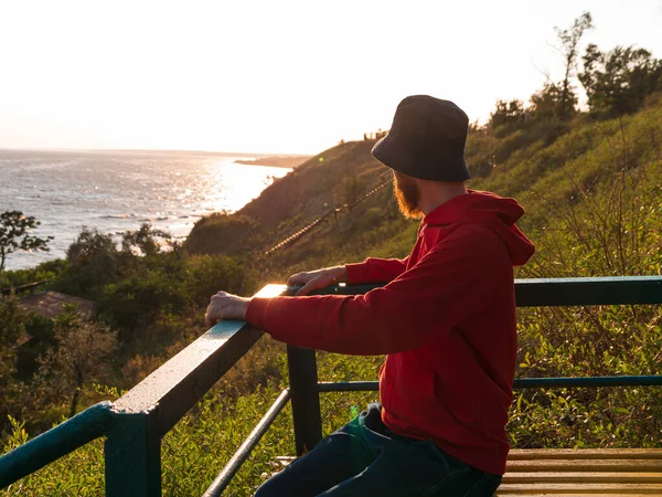 Millennial Man Bucket Hat Red Hoody Eyeglasses Bench Autumn Sea — Stock Photo, Image