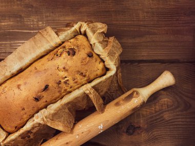 Kırsal ahşap arka planda merdaneli kek yapmak. Hamur tarifi içeriği, yumurtalı tam tahıllı süt yağı şekeri yukarıdaki eski ahşap masa üzerinde. Üst manzara mutfak düzeni