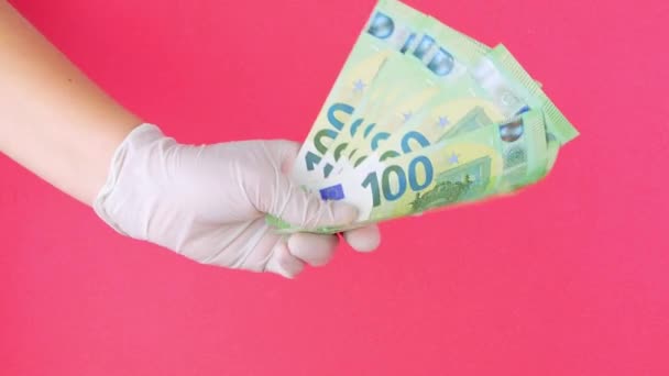 Ręka Ochronnej Rękawicy Medycznej Posiada Euro Rachunki Pieniężne Różowym Tle — Wideo stockowe