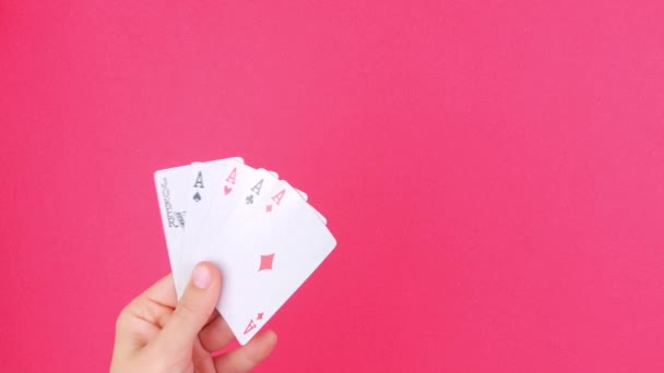 ギャンブラーの手の中の5種類のポーカーゲームカードはピンクの背景を紙幣 ラッキーコンビネーションエースとジョーカー明らかに オンラインギャンブルカジノゲーム受賞者の成功ベットコンセプトエンターテイメント — ストック動画