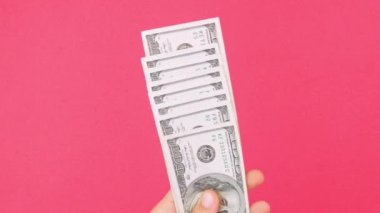 El, Amerikan Doları 'nı tutuyor. Para, pembe renkli arka plan. 100 Amerikan Doları 'nı sayıyorum. Amerikan para birimini tasarruf etmek, zenginlik kavramı. Çevrimiçi kumarhane kazananı başarılı ticaret