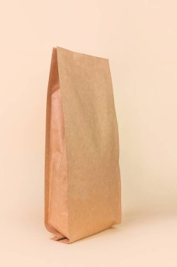 Sachet çanta, nötr bej arka plan monokromu. Malzeme ambalajı. Boş kahverengi Kraft kağıt paketi kahve çekirdeği ürün şablonu. Atıştırmalık çerez, dükkan alışverişi.