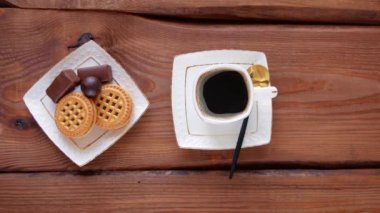 Tahta masada şekerli buharlı kahve. Sıcak taze demlenmiş espresso kahvesi, buharlı beyaz bardakta. Üst tabakta çıtır çıtır çikolatalı şekerler. Restoran içkileri lezzetli kahvaltı menüsü.