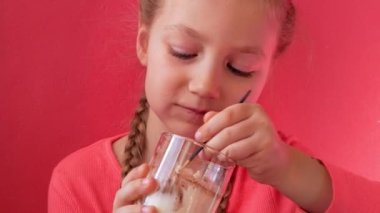 Yoğurt yiyen pembe arka plan. Süt ürünleri diyeti Lactobacillus Acidophilus, ev yapımı sağlıklı kahvaltı menüsü. Çocuk sağlık hizmetleri. Vejetaryen fındık sütlü jelatin sütsüz tatlı Protein pudingi.