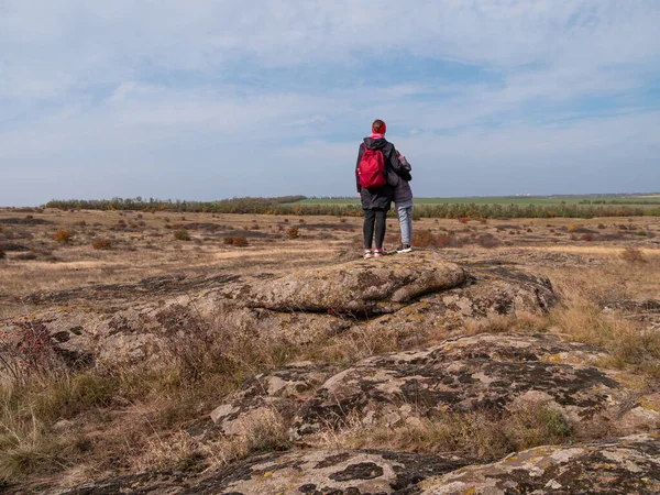 Gezgin anne kızı dağ zirvesinde el kaldırıyor birlikte yürüyüş yapıyor manzaranın tadını çıkarıyor bulutlu gökyüzünün tadını çıkarıyor. Aktif yaşam tarzı, aile ortamında ebeveynlik günlerinde eğleniyor.