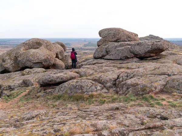 Dağ zirvesinde akıllı telefon ve sırt çantalı bir gezgin kadın. Manzaralı manzaranın fotoğrafını çeken bir kız. Aktif Yaşam Tarzı Turizmi. Solo gezintisi aşırı doğa aktivitesi