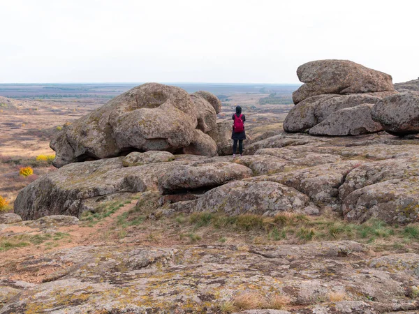 Dağ zirvesinde akıllı telefon ve sırt çantalı bir gezgin kadın. Manzaralı manzaranın fotoğrafını çeken bir kız. Aktif Yaşam Tarzı Turizmi. Solo gezintisi aşırı doğa aktivitesi