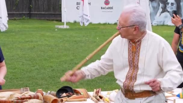 ソフィルカ族の木管楽器フルートの家族を演奏するミュージシャンの男 収縮した端を持つフィップルを組み込んだレコーダーに似ています ウクライナの民俗音楽祭 ライブ ウクライナ5月14 2022 — ストック動画