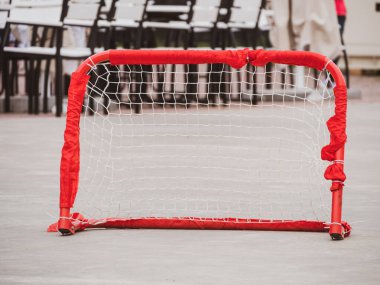 Floorball topu antrenman için hazır. Çocuklar baharda dışarıda oynuyorlar. Top ve sopayla koşan hokey oyuncuları kaleci. Boş zamanların dışında, aktif yaşam tarzı çocuklar spor yapıyor..