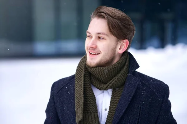Portrait of handsome happy positive cheerful guy, young successful blonde European businessman in formal clothes or student in coat, shirt scarf is smiling outdoors at winter cold snowy day in snow — 图库照片