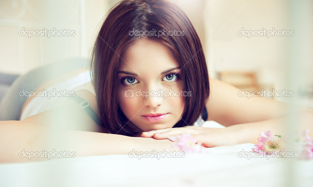 Beautiful young woman on the bed