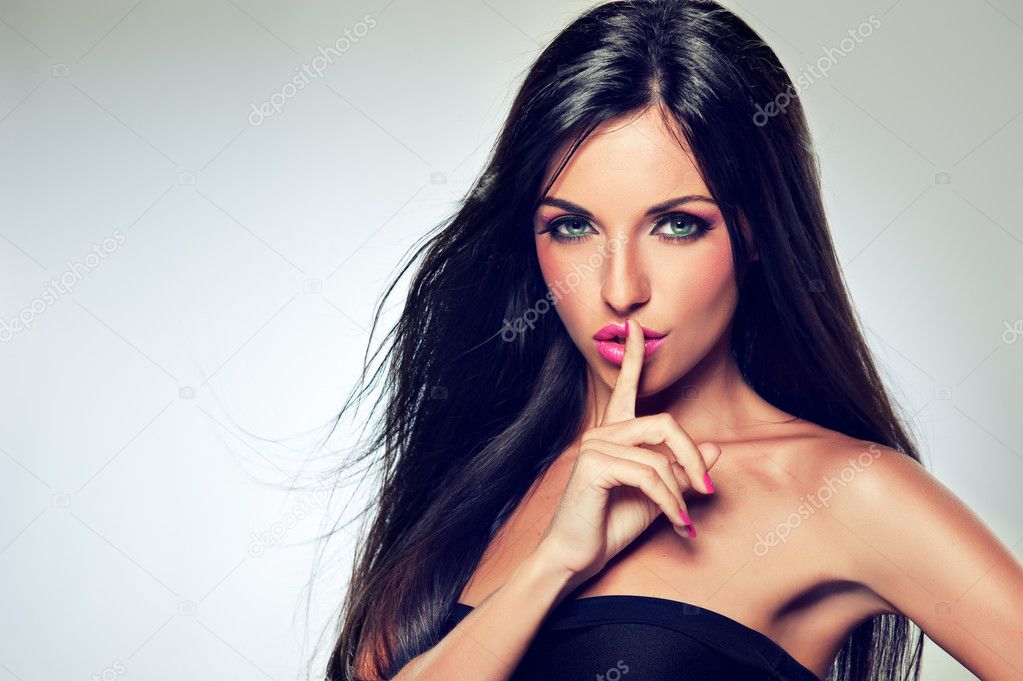Brunette woman showing silence gesture