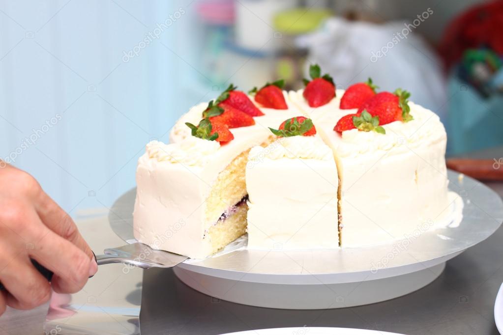 hand holding milk cake with topping  strawberry.